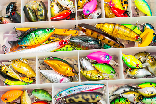 Colorful fishing lures and accessories in the box background