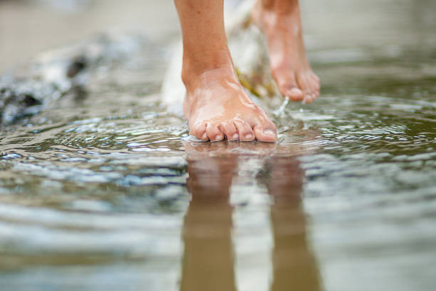 istock Girls legs on the water 587818242