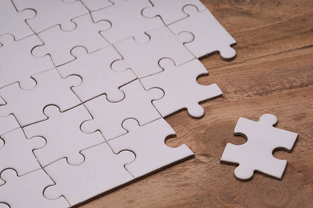 istock Incomplete puzzles on wooden table. 587879336