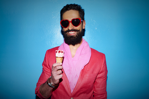 Portrait of a bearded arab hipster in sunglasses eating ice-cream