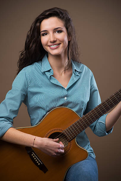 istock Beautiful girl playing guitar 587883150