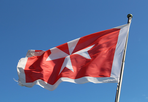 Maltese flag against a blue sky