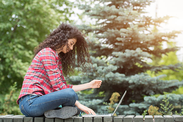 istock Beautiful university student study with laptop in the campus garden 587886318