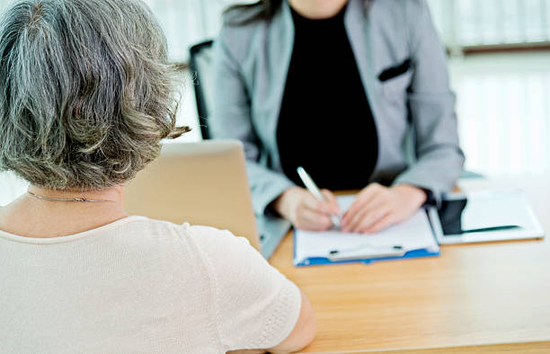 istock Senior asian woman talking with her counselor 587889090
