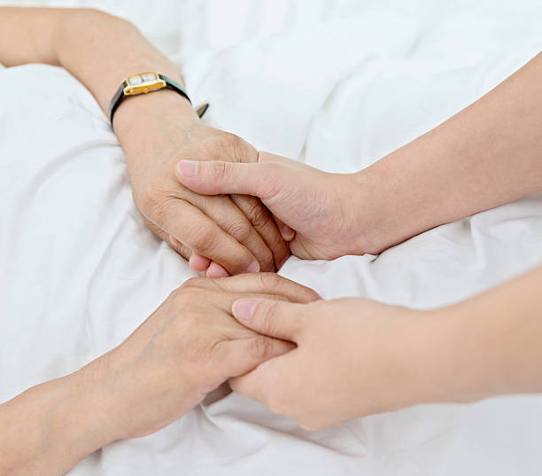 istock Young hands holding a senior woman's hands 587895532