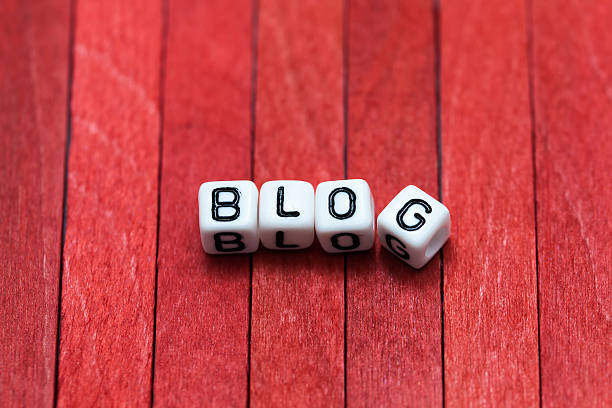 istock BLOG cube blocks arranged on red wooden background 587896738