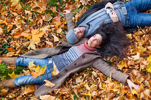 istock Young people lying down on autumn leafs carpet 587898746