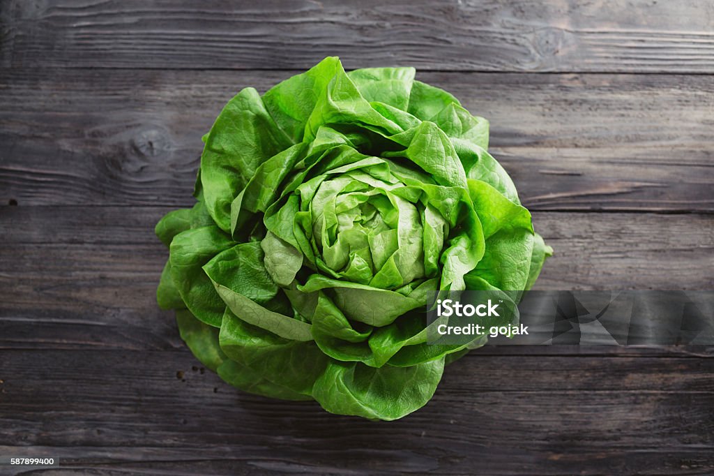 Fresh lettuce Single lettuce head over rustic wooden background Color Image Stock Photo