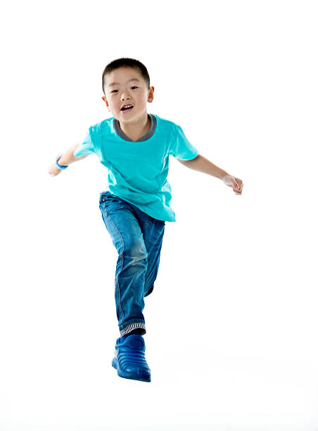 istock Young asian boy jumping against white background 587899994