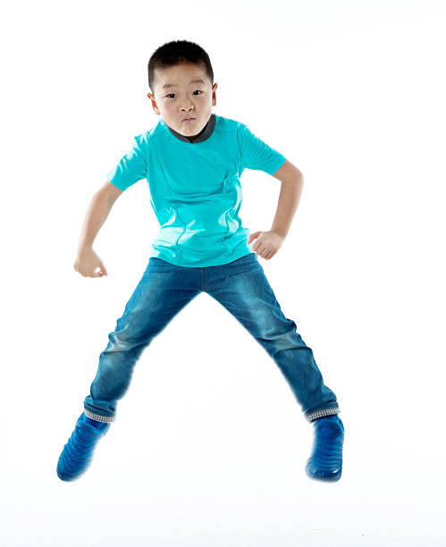 istock Young asian boy jumping against white background 587900092