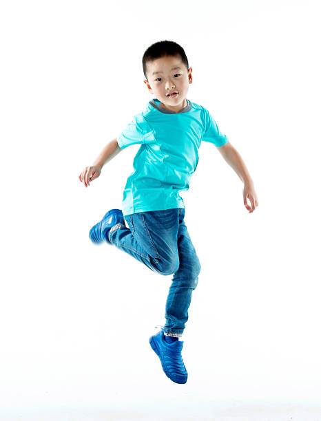 istock Young asian boy jumping against white background 587900186
