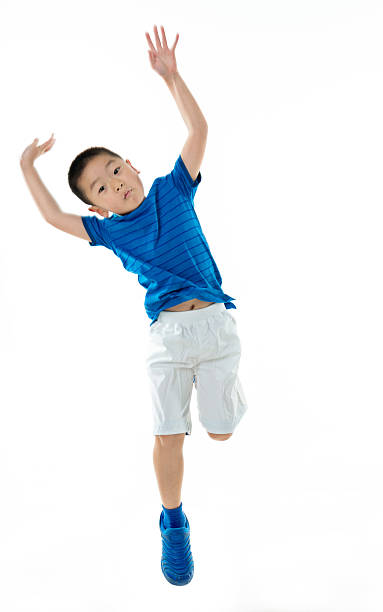 istock Young asian boy jumping against white background 587900330