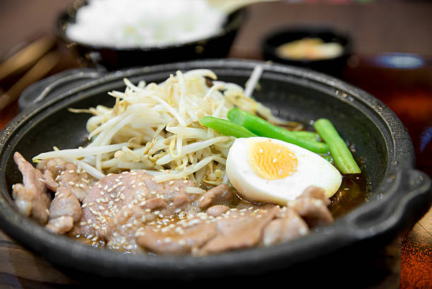 Korean spicy bbq pork served on a hot plate with side dishes and rice. Korean traditional food.