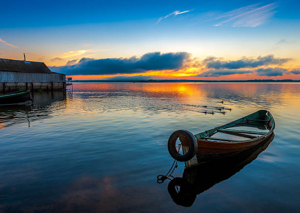 Sunrise on Lake Seliger with an old boat in the foreground, Ostashkov, Tver region, Russia.