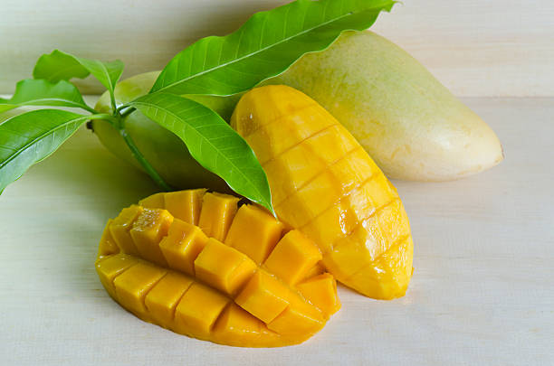 istock Mango ripe with nicely cut pieces and leaf on wood 587915358