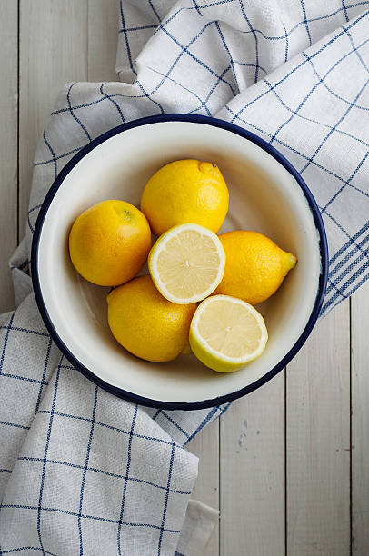 Five lemons in white bowl stock photo