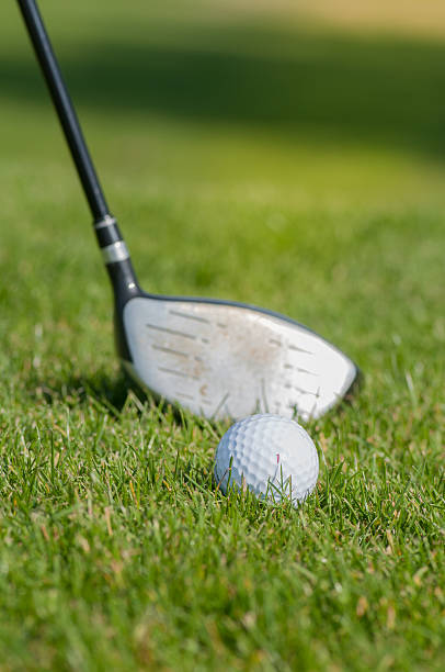 istock Golf ball and golf club in green grass 587928520