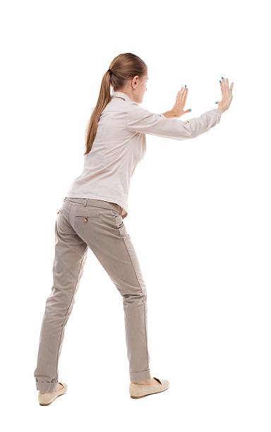 istock back view of woman pushes wall. 587928598