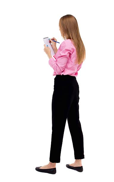 istock back view of  stands woman takes notes in a notebook 587928818