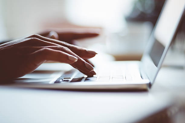 istock Woman using a laptop indoors, close up of hands 587929098