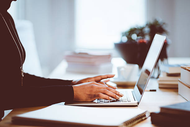 istock Woman using a laptop indoors, close up of hands 587929218