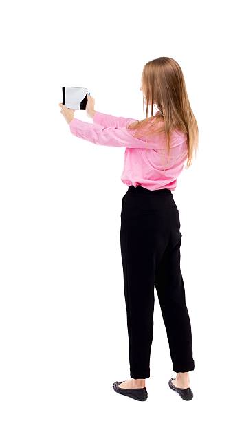 istock back view of standing young beautiful  girl with tablet computer 587929352