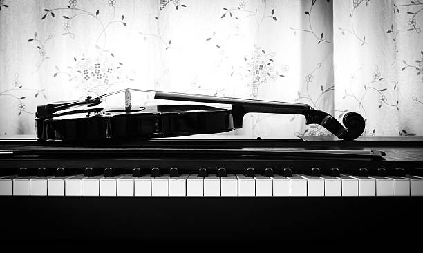 violin on piano. black and white theme. - piano piano key orchestra close up imagens e fotografias de stock