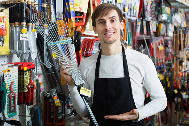 istock Salesman with leaf rake in supermarket 587931210