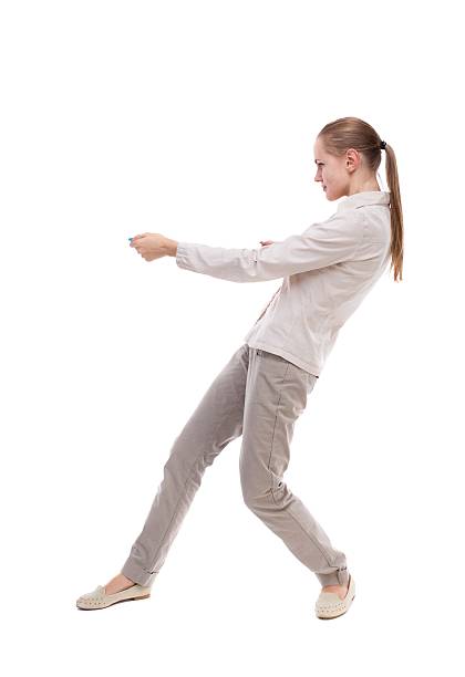 istock back view of standing girl pulling a rope from the 587931318