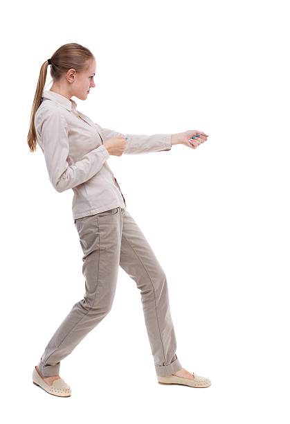 istock back view of standing girl pulling a rope from the 587932282