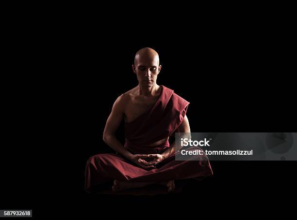 Buddhist Monk In Meditation Pose Over Black Background Stock Photo - Download Image Now
