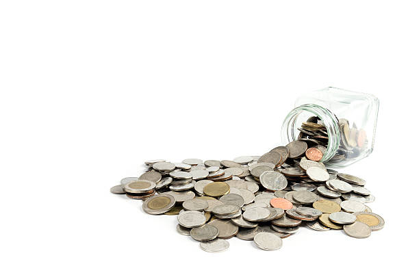 istock Coins spilling out of glass jar 587932794