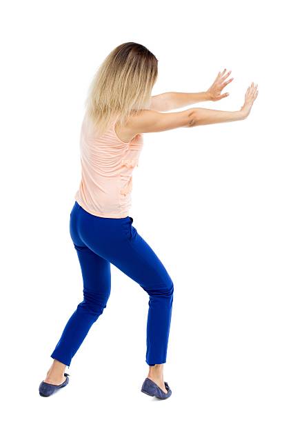 istock back view of woman pushes wall. 587934240