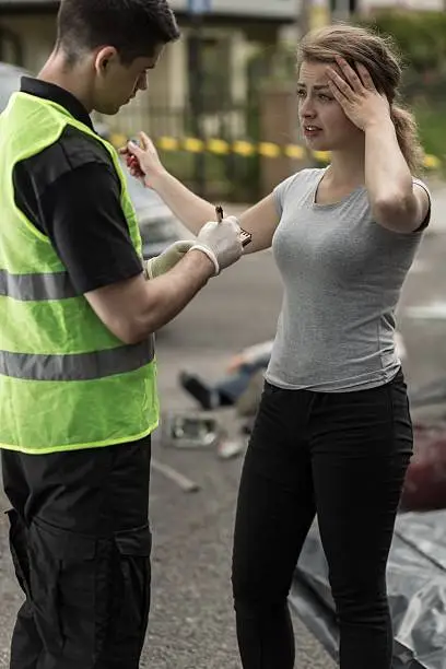 Young woman is telling policeman about car accident