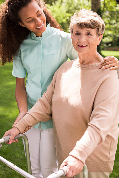 istock Helpful caregiver with senior 587940776