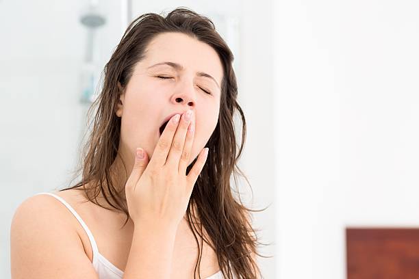 istock Young woman yawning 587941608