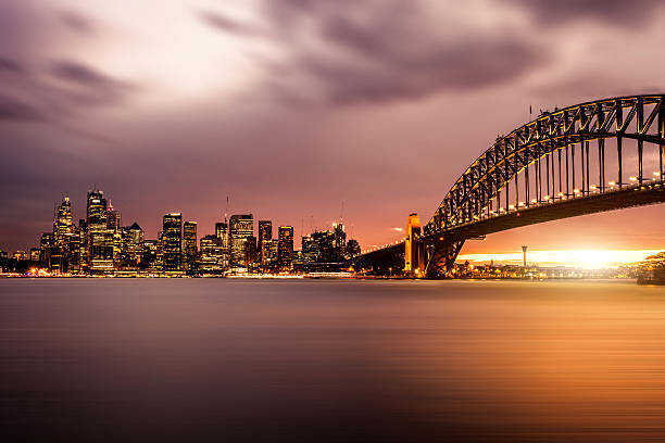 Cityscape of Sydney Downtown and Harbor Bridge Cityscape of Sydney Downtown during a beautiful sunset. CBD and Sydney Harbor sydney skyline sunset stock pictures, royalty-free photos & images