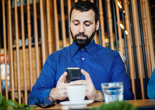 istock Mature man playing mobile gaming app during coffee break 587943162