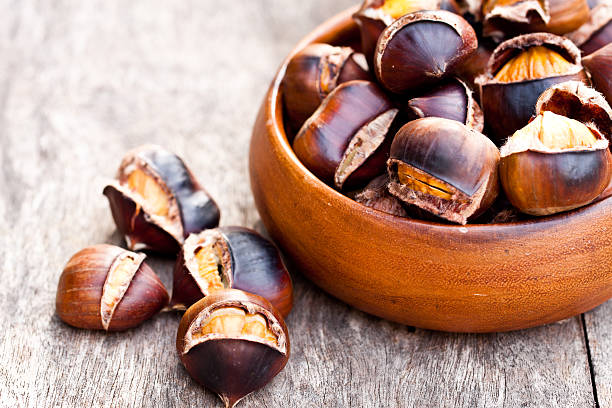 istock Roasted  chestnuts on wooden background 587943168
