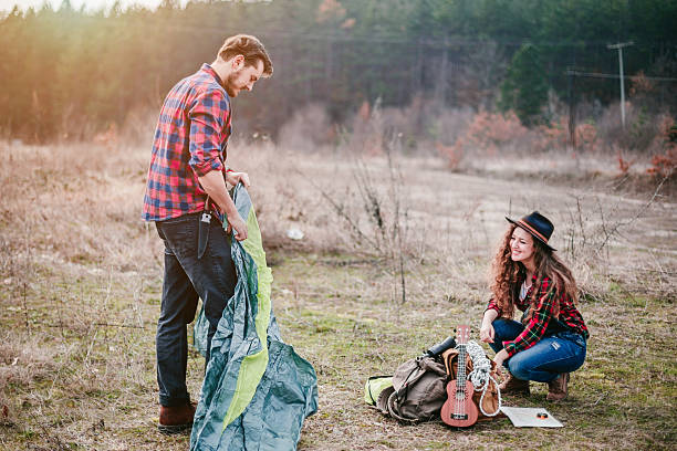 istock Young couple sets a tent in a campsite 587943288