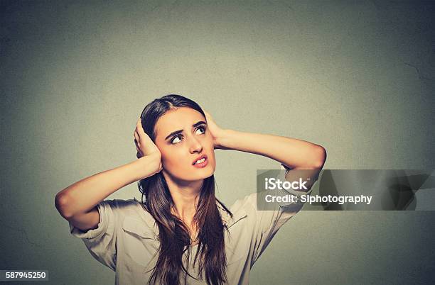 Stressed Woman Covering Ears Looking Up Loud Noise Upstairs Stock Photo - Download Image Now