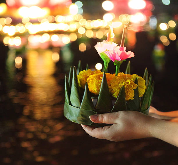 Woman holding kratong in her hands Woman holding boat with candles and flowers are given for Thailands traditional Loy Krathong Festival. DOF. Photo in motion and in the dark krathong stock pictures, royalty-free photos & images