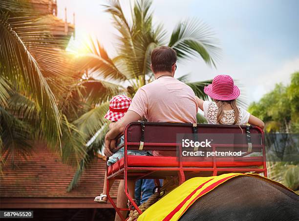 Man And His Daughters Riding On The Back Of Elephant Stock Photo - Download Image Now