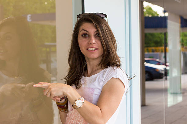 istock Happy girl looking in shop window 587945526