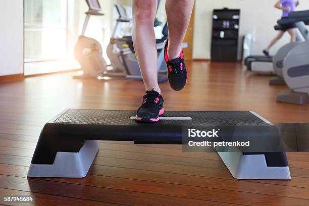 Young Woman Doing Step Aerobics While In Health Club Stock Photo - Download Image Now