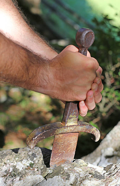 istock Knight and the famous Excalibur sword in the stone 587950436