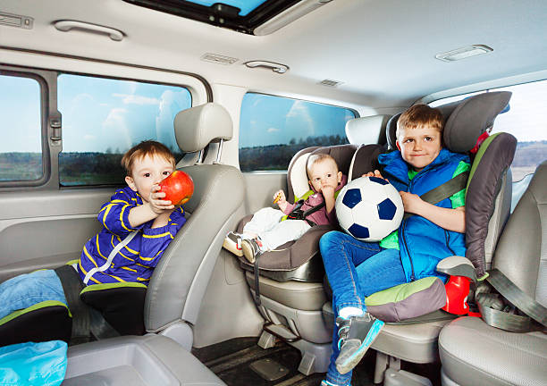 nette kleine jungen, die mit dem auto in sicherheitssitzen unterwegs sind - soccer child indoors little boys stock-fotos und bilder