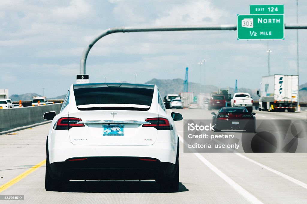 Tesla Model X on the road in Arizona. Phoenix, AZ, USA - May 6, 2016: Brand new white electric car Tesla Model X on the highway in Arizona. Rear View Stock Photo
