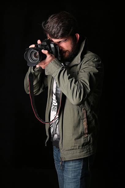 istock Man dressed in khaki jacket takes picture. Close up. Black 587951642