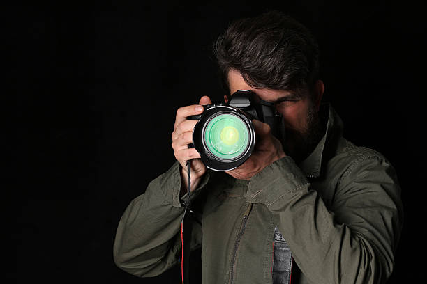 istock Man takes picture. Close up. Black background 587951760